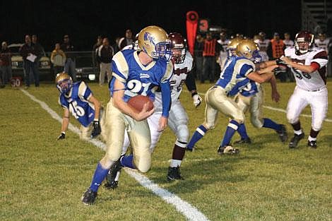 Jason Shueh/Valley Press Quarterback Will Dalby dodges the Troy defensive linemen to make a 60-yard touchdown rush.