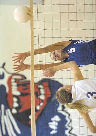 CUTLINE: Warden setter Ivory Kisler misses a block attempt against Columbia-Burbank's Shana Smith in game four Thursday night. The Lady Cougars lost the match, but still qualify for the district playoffs starting Tuesday.