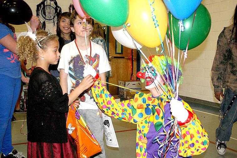 <p>Jade Hunter gets a balloon from a clown, Nicki Tourtelette, during Superior Elementary School's Halloween party Friday evening. The party featured treats, games and a costume contest.</p>