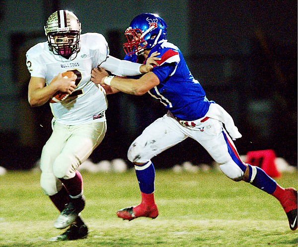 &lt;p&gt;Choteau Quarterback Austin Walker (left) just manages to escape a sack by Bigfork's Hank McLeod during their game on Friday in Bigfork.&lt;/p&gt;