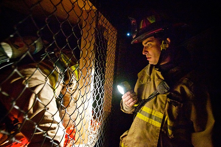 &lt;p&gt;JEROME A. POLLOS/Press Lt. Justin Capaul, with Kootenai County Fire and Rescue, momentarily shines his light to observe a firefighter crawling through an enclosed space during a &quot;confidence&quot; training session Friday in Post Falls. The training facility was built inside a storage container with funds raised through the firefighters union.&lt;/p&gt;