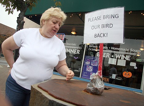 &lt;p&gt;Eva Itskos, co-owner of Olympia restaurant, stands outside her business Friday where she has placed a sign asking politely for the return of the blue heron statue that was stolen last week.&lt;/p&gt;