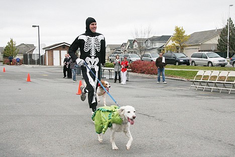 &lt;p&gt;Daniel Shaw of Coeur d'Alene races the Pumpkin 5K Fun Run and Food Drive at Coeur d'Alene Place on Saturday. His dogs Chloe, in green, and McKinley ran by his side.&lt;/p&gt;