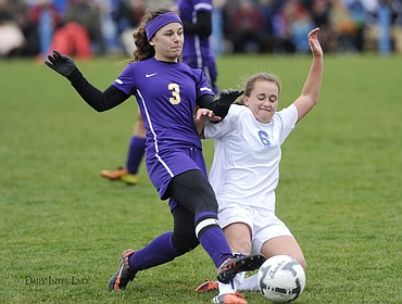 <p>Columbia Falls junior midfielder Katie Price slides to take the ball away from Laurel's Kyra Elmer (3) during the first half of the Class A girls state soccer championship match on Saturday in Columbia Falls. (Aaric Bryan/Daily Inter Lake)</p>