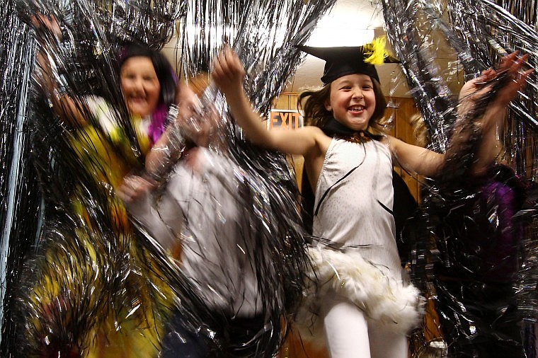 Devin Paine, right, jumps through a wall of streamers in the entrance to the new Bigfork Playhouse Children&#146;s Theatre Fine Arts Center.