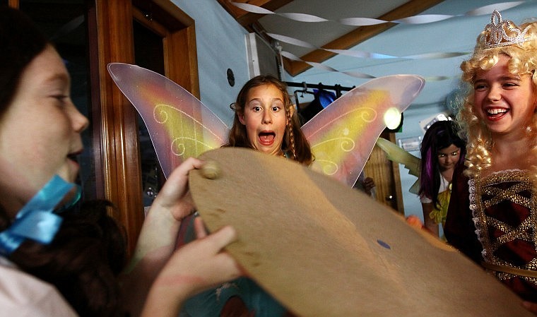 Wilson Vogt reacts as she watches Dylan Schmidt, left, attempting to keep an egg rolling on a board while Sarah Ward looks on.