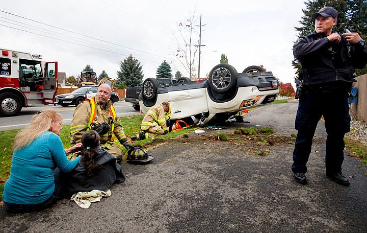 &lt;p&gt;Crews from the Coeur d'Alene fire and police departments work the scene of a rollover accident involving two vehicles on Thursday, Oct. 6, 2016 at the intersection of 15th Street and Margaret Avenue in Coeur d'Alene. A woman, seen in the background being removed from the overturned SUV, was taken to Kootenai Health with leg and other non-life threatening injuries. Her young daughter, seen in the foreground, walked away unscathed. The cause of the accident is under investigation.&lt;/p&gt;