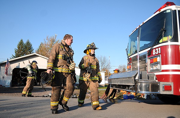 &lt;p&gt;Evergreen firefighters Jared Pitcher, left, and Jackie Smith
walk away from the site of a house fire on Thursday morning on
Dogwood Avenue in Evergreen.&lt;/p&gt;