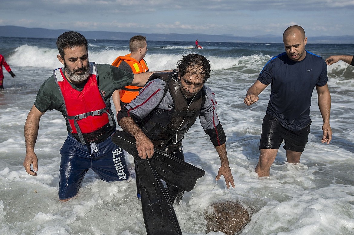 &lt;p&gt;Volunteers take a possible smuggler to shore on Lesbos, Greece, Saturday afternoon after the man was rescued by two Spanish lifeguards as he attempted to float back to Turkey on a partially deflated raft after delivering a group of refugees. He was later delivered by volunteers from Drop in the Ocean to a police station in Molyvos.&lt;/p&gt;