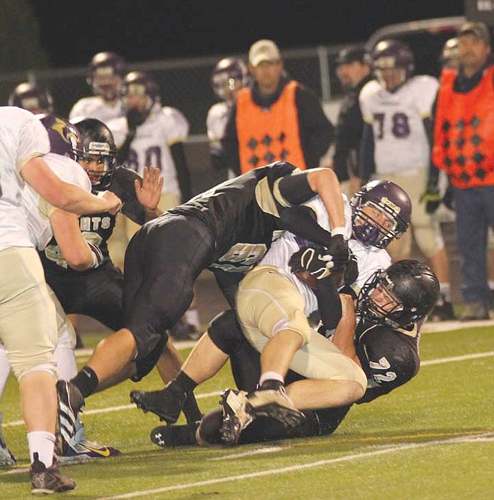 Teddy Mead, on top, and Collin Christensen of Royal sandwich a Burbank ball carrier during last Friday's game.
