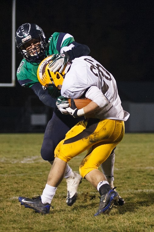 <p>Patrick Cote/Daily Inter Lake Glacier senior Kyle Griffith (3) wraps up a Helena Capital runner Friday night during Glacier's playoff victory over Helena Capital at Legends Stadium. Friday, Nov. 2, 2012 in Kalispell, Montana.</p>