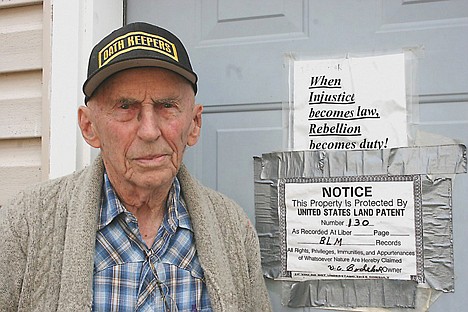 &lt;p&gt;Renn Bodecker, 90, stands in front of the door to his home, where signs depict rights he's fighting for.&lt;/p&gt;