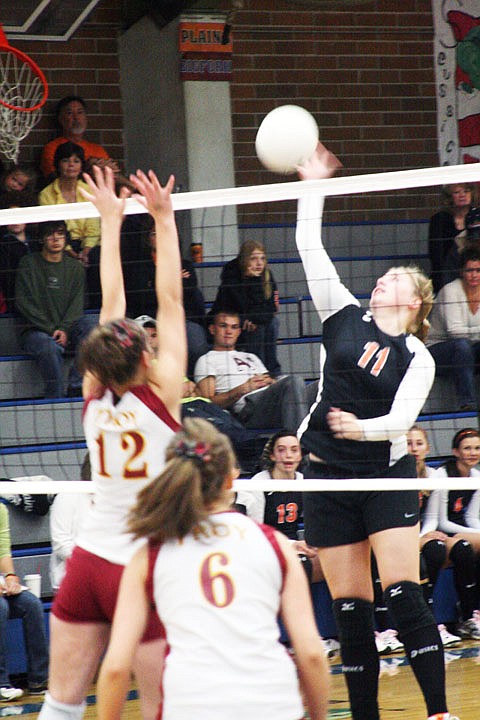 Kayla Revier goes over the top of two Trojans for a kill on Saturday morning.