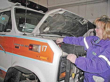 Penny Kyes with Libby Volunteer Ambulance puts a battery charger on an ambulance. Voters on Nov. 7 will be asked to support a 2-mill tax increase for volunteer ambulance companies in Libby, Troy and Eureka.