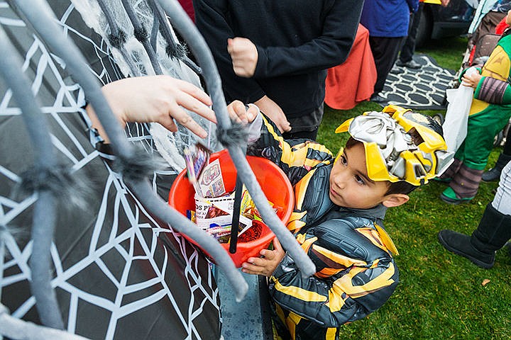 &lt;p&gt;SHAWN GUST/Press&lt;/p&gt;&lt;p&gt;Braxson Seath, 5, hoists his bucket up for a mysterious hand that drops candy from the back of a vehicle at a park near the intersection of Sixth Street and Sherman Avenue Friday as part of the Coeur d&#146;Alene Downtown Association&#146;s new &#147;Trunk or Treat&#148; event.&lt;/p&gt;