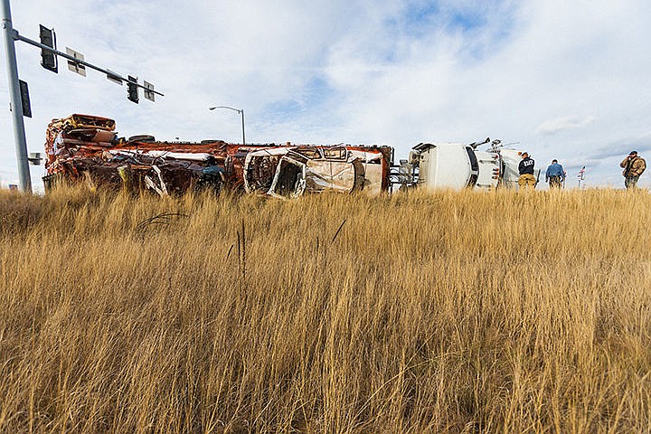 &lt;p&gt;SHAWN GUST/Press&lt;/p&gt;&lt;p&gt;Truck driver Kevin Edwards, far right, talks on the phone as Coeur d&#146;Alene Fire Department crews check for leaks coming from a truck, carrying a load of crushed scrap vehicles, tipped onto its side on the eastbound on-ramp of Interstate-90 near U.S. 95 Monday in Coeur d&#146;Alene. No injuries were reported in the accident.&lt;/p&gt;