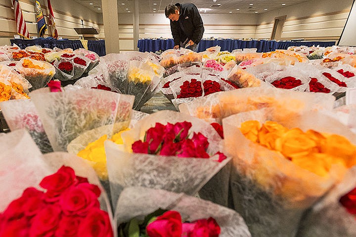 &lt;p&gt;SHAWN GUST/Press&lt;/p&gt;&lt;p&gt;Coeur d&#146;Alene Rotary Club member places cards in rose bouquets at the Coeur d&#146;Alene Resort Friday prior to pick and distribution of 1,200 dozen roses. The roses were sold earlier this month as part of the 25th annual rose sale fundraiser for the group.&lt;/p&gt;