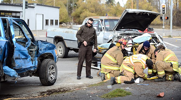 &lt;p&gt;From left, Nelson Grant of the Flathead County Sheriff's Department examines damage to a truck involved in a two vehicle accident as James Boyce, Craig Williams and members of the Evergreen Fire Department work to get one of the drivers onto a stretcher on Monday, October 28, on Highway 2 in Evergreen. (Brenda Ahearn/Daily Inter Lake)&lt;/p&gt;