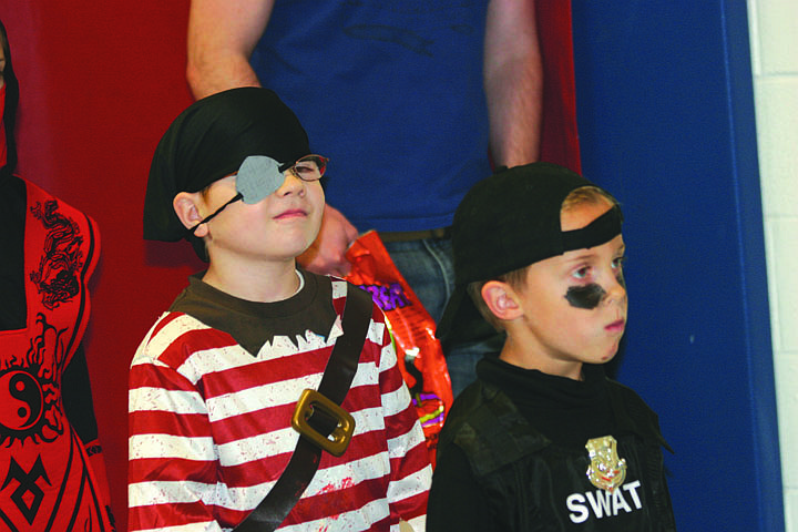 Christian Faller as a pirate and Decker Milender as a member of the SWAT team wait to play a game on Halloween night.