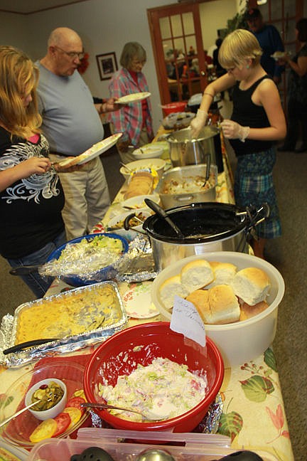 &lt;p&gt;Anna, 12, serves up grub to Chester Crow Thursday at the Fellowship Baptist Church&#146;s Harvest Community Dinner in Polson. Courtney, 11, waits her turn while Maria Tribur checks the table.&lt;/p&gt;