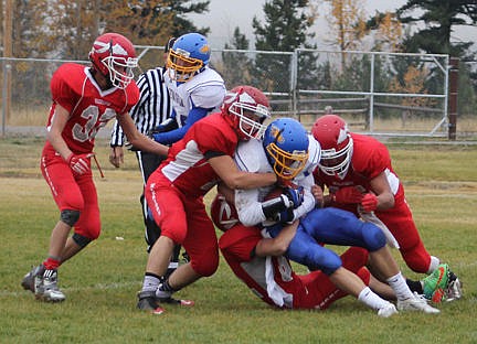 &lt;p&gt;A gang of Warriors makes a tackle at the line of scrimmage during a chilly drizzle.&lt;/p&gt;