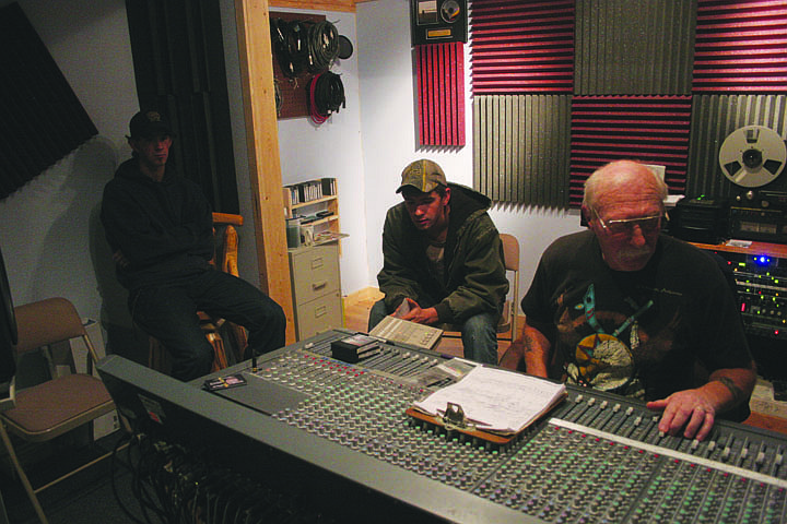 Kenley and Roman Zylawy listen to their music CD as Chuck Seward adjusts some levels at Seward's recording studio.