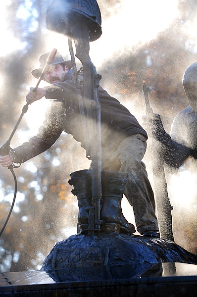 Zach Ginnaty power washes the top of the Veteran's Memorial on Wednesday morning in Kalispell.