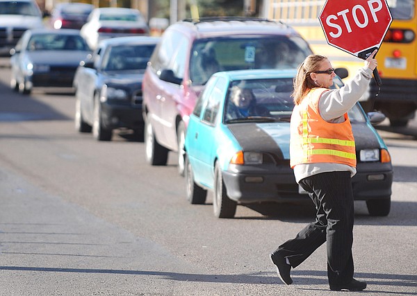 Chrystal Shue of Evergreen stops a line of vehicles as students are dismissed from Evergreen Junior High on Tuesday afternoon.