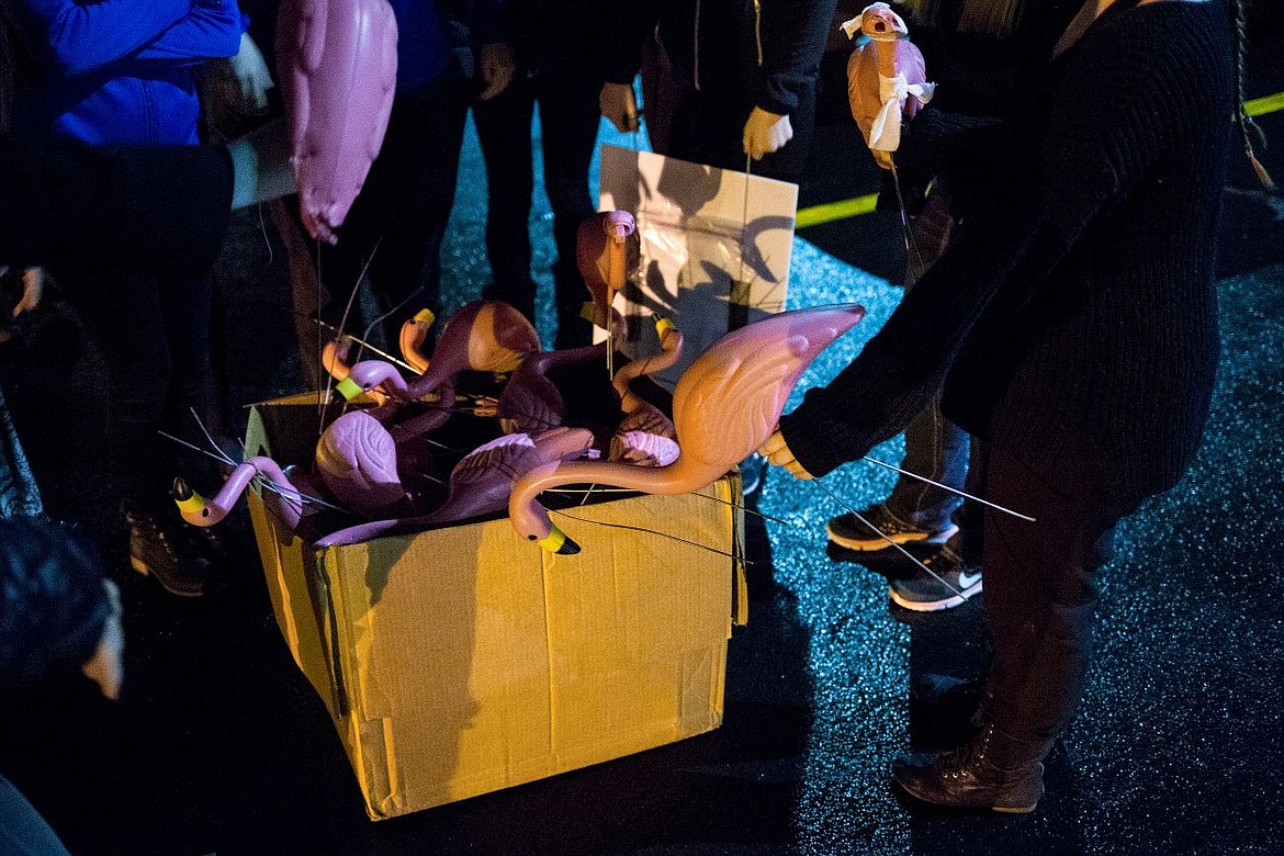 &lt;p&gt;Members of the Coeur d'Alene High School dance team grab plastic flamingos, some bandaged up after a dog mangeled them, out of a box before placing them in front of the North Idaho Physical Therapy sign on Thursday in Coeur d'Alene.&lt;/p&gt;