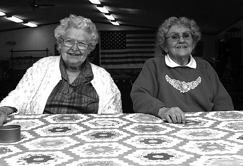 Mary Arden and Betty Gerrity joke around with one another while stitching quilts. They are experts at stitching and make a lovely team. Photo by Erin Scott