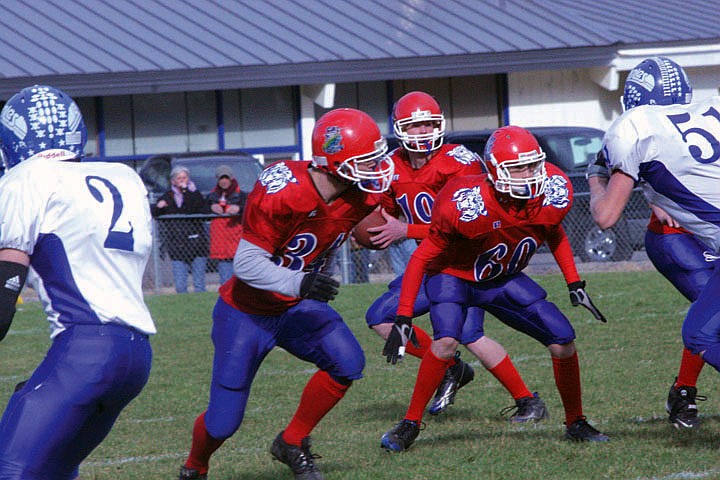 Christopher Eriksson and Dan Taron protect quarterback Tanner Coon as he looks for his man to throw the ball downfield.