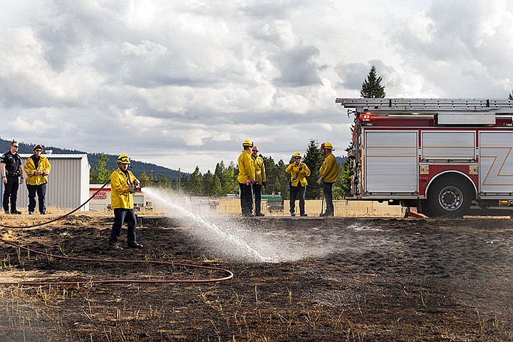 &lt;p&gt;Firefighters with Kootenai County Fire and Rescue douse the shoulder of Interstate-90 west of Highway 41 after extinguishing a small grass fire Wednesday afternoon. The cause of the fire is under investigation.&lt;/p&gt;