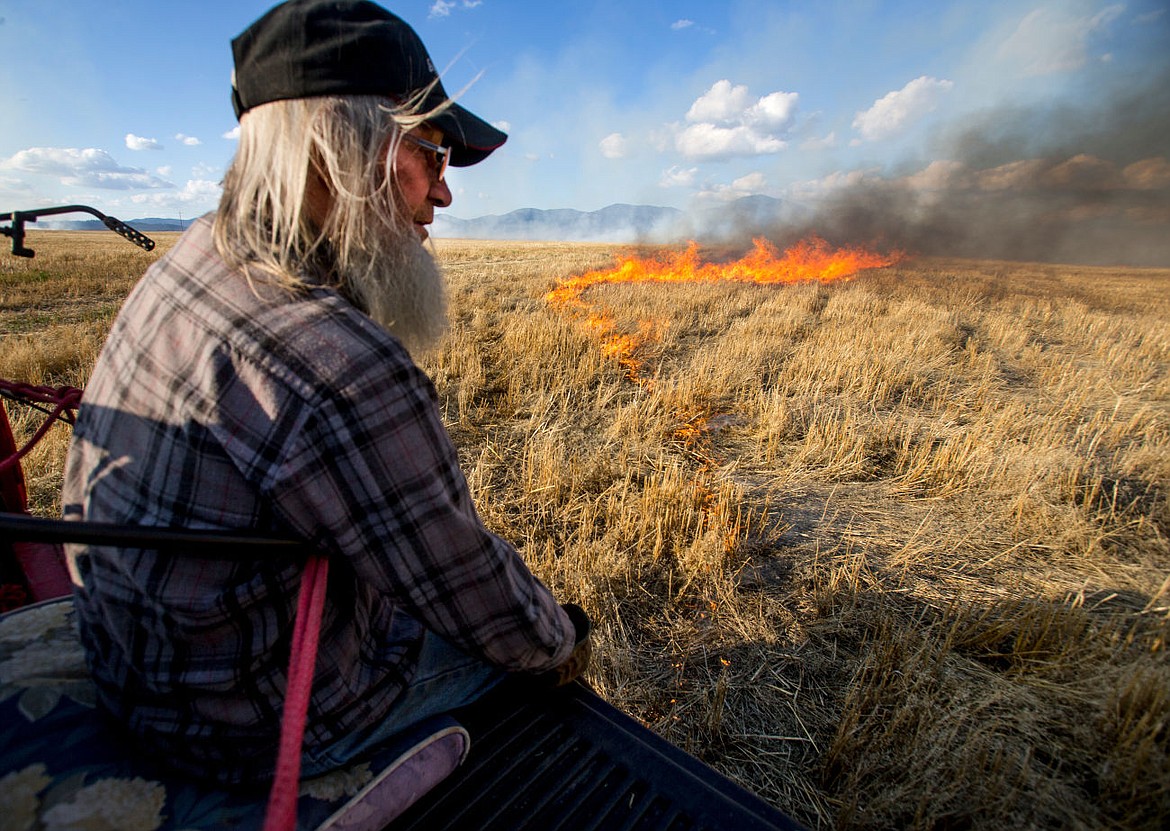 &lt;p&gt;Don L. Butler sits on the tailgate of a pickup truck as he lights a wheat field on fire using a wheat burning torch to help the field recycle its crops on Thursday near the intersection of Greensferry Road and Hayden Avenue north of Post Falls. 150 acres were burned.&lt;/p&gt;