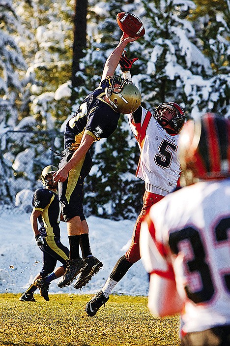 <p>Timberlake High's Preston Rhodes goes in an attempt to bring down a pass just out of his reach in front of Zach Huff from Fruitland.</p>