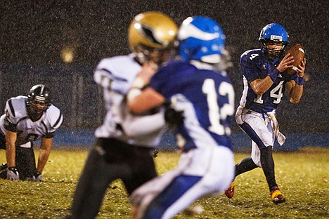 &lt;p&gt;After catching a pass, Coeur d'Alene High's Carlos Martinez handles a wet football as rain pours onto the field in the first half.&lt;/p&gt;