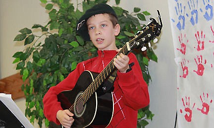 &lt;p&gt;Noah, 9, plays the guitar while his group sand patriotic songs.&lt;/p&gt;