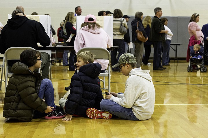 &lt;p&gt;SHAWN GUST/Press Emerye Murrell, 9, far left, waits on the gymnasium floor with her brothers Gavvyn, 7, and Caed, 11, right, as their parents cast their vote Tuesday at Skyway Elementary School in Coeur d'Alene.&lt;/p&gt;