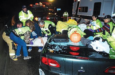 Bruce Charles/Courtesy photo Members of the West End Volunteer Fire Department help a victim out of a car Sunday evening. Rescuers used a hydraulic cutting device.