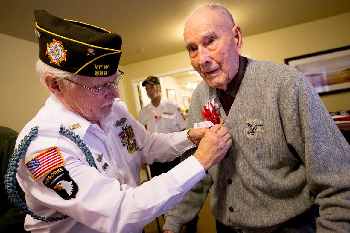 &lt;p&gt;VFW Post 889 Post Commander and 20-year Army veteran Bob Martin pins a red poppy onto the sweater of 101-year-old World War II veteran Ralph Ward on Friday at Brookdale Senior Center in Coeur d&#146;Alene.&lt;/p&gt;