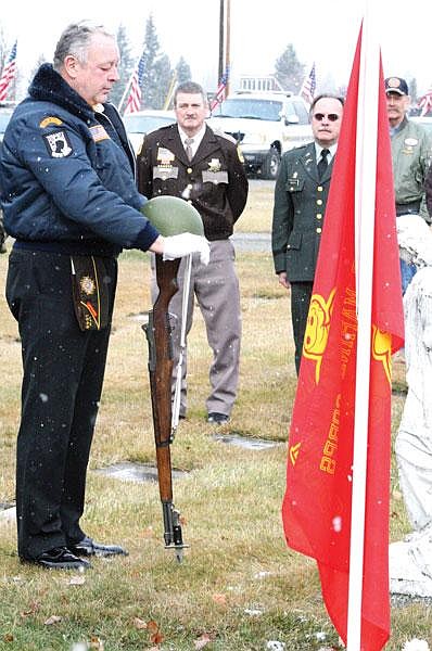 Brad Fuqua/The Western News Ron Parker of the VFW Harper Erdman Post No. 1548 in Libby completes the presentation of honors and colors by placing his helmet on an old M-1 rifle during a ceremony Wednesday at the City of Libby Cemetery. Parker served as a combat medic with the U.S. Army.