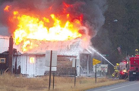 Jennifer McBride/Valley Press Firefighters rush to put out the flames at the Pair-a-Dice bar in Paradise.