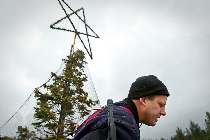 &lt;p&gt;John Eloe looks down to a crane operate Friday from more than 130 feet off the ground after checking the netting that supports the strands of lights for the World's Tallest Animated Tree that is the centerpiece of &quot;The Journey to the North Pole&quot; cruise.&lt;/p&gt;