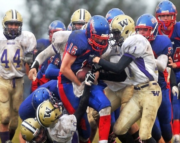 Bigfork quarterback Christian Ker (16) gets swarmed by a pack of Cut Bank Wolves as he carries the ball upfield.