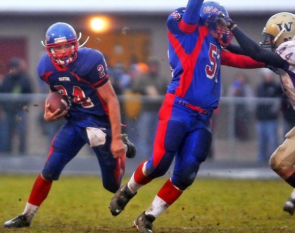 Bigfork's Travis Knoll (24) looks for an opening as he gets some blocking help from teammate Austin Curtis (57) who defends against Cut Bank's Ryan Gobert (44).