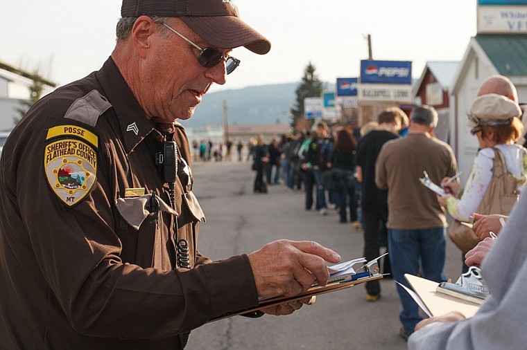 &lt;p&gt;Patrick Cote/Daily Inter Lake Sgt. Jerry Thornburg of the Flathead County Sheriff's Posse hands out registration forms to a long line of voters Friday afternoon outside the county election office at the Flathead County Fairgrounds in Kalispell. Tuesday, Nov. 6, 2012 in Kalispell, Montana.&lt;/p&gt;