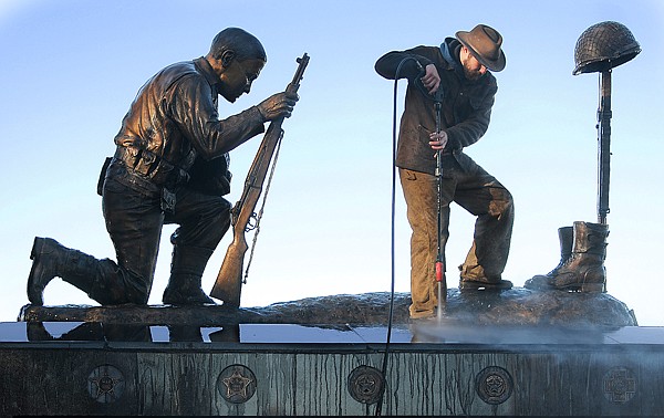 Zach Ginnaty power washes the top of the Veterans Memorial on Wednesday morning in Kalispell. The memorial and the walkway will be thoroughly cleaned and will have new bricks and new bronze plates installed in time for the Veterans Day ceremony which will take place on Thursday the 11th at 11 a.m.