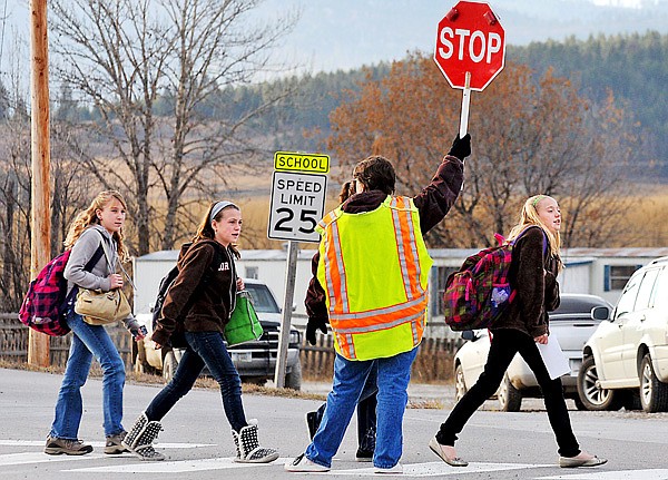 Crossing Guard Dorothy Lofgren holds up a sign for students from Smith Valley School to cross Batavia Lane on Tuesday afternoon. The speed limit in the school zone on US 2 drops to 45 mph during school hours and to 25 mph on Batavia Lane.  Principal Laili Komenda worries about the proscpet of an accident at the intersection. &#147;We&#146;re making it as safe as we can,&#148; she said. &#147;We&#146;ve done a great job of having nobody hurt yet, but we don&#146;t want to look back and say, &#145;Oh, we should have.&#146;&#148;