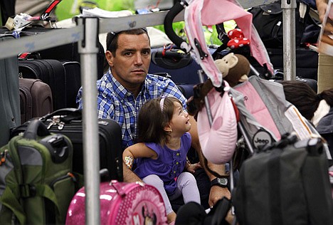 &lt;p&gt;In this Nov. 23, 2011, file photo, Jose Mendes sits in line with his daughter Maria Celeste Mendes at an air ticket counter waiting to travel before the Thanksgiving holiday weekend at Miami International Airport, in Miami. Airlines are making it much more difficult for groups of travelers to sit together, unless they want to pay extra for seats with more legroom or those near the front of the plane. Since last Thanksgiving, American Airlines, Delta, Frontier and United have increased the number of coach seats requiring an extra fee. That means it's much more difficult to find adjacent seats unless passengers pay an extra $25 per person, each way.&lt;/p&gt;