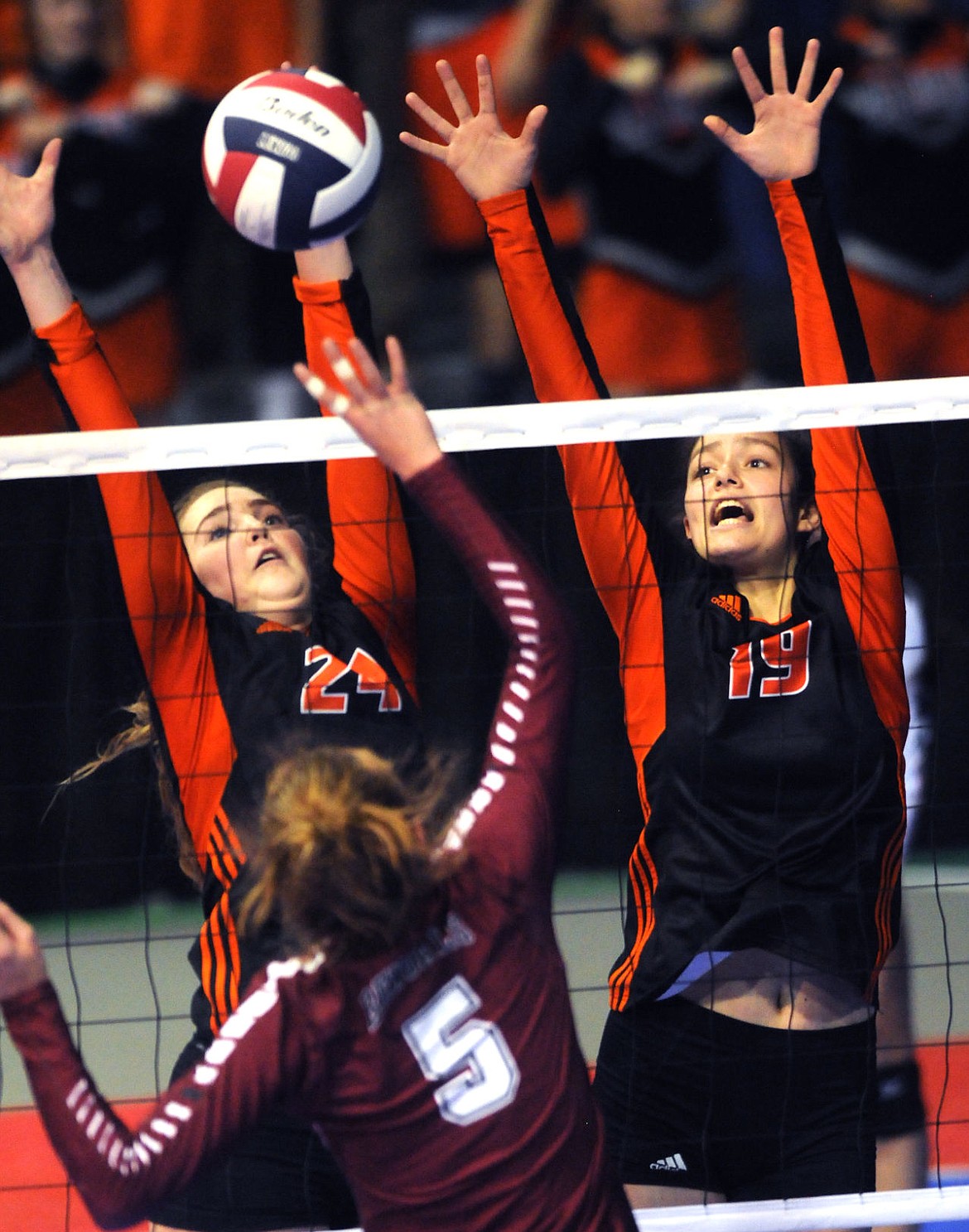 <p>Flathead's Xio Lopp (24) and Alyssa Wisher (16) attempt to block the shot of Helena's Taelyr Krantz during the Bravettes' five-set loss in an elimination game at the state tournament in Bozeman on Friday. (Aaric Bryan/Daily Inter Lake)</p>