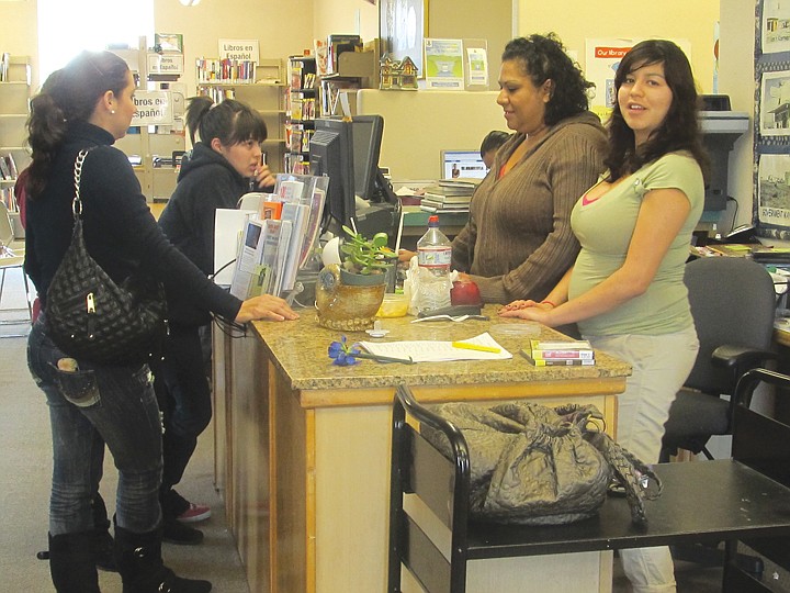 Librarian Josie Toscano, at computer, and her assistant Rosa
Cisneros, to her left, attend to the needs of Mattawa Public
Library users.